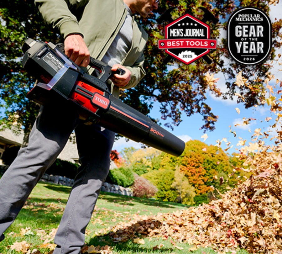 Toro 51827T 60V MAX 900 CFM handheld leaf blower shown in a yard.